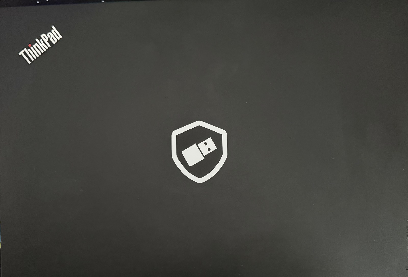 Closed lid of the NitroPad T480: ThinkPad and Lenovo logos, with the Nitrokey shield sticker in the centre